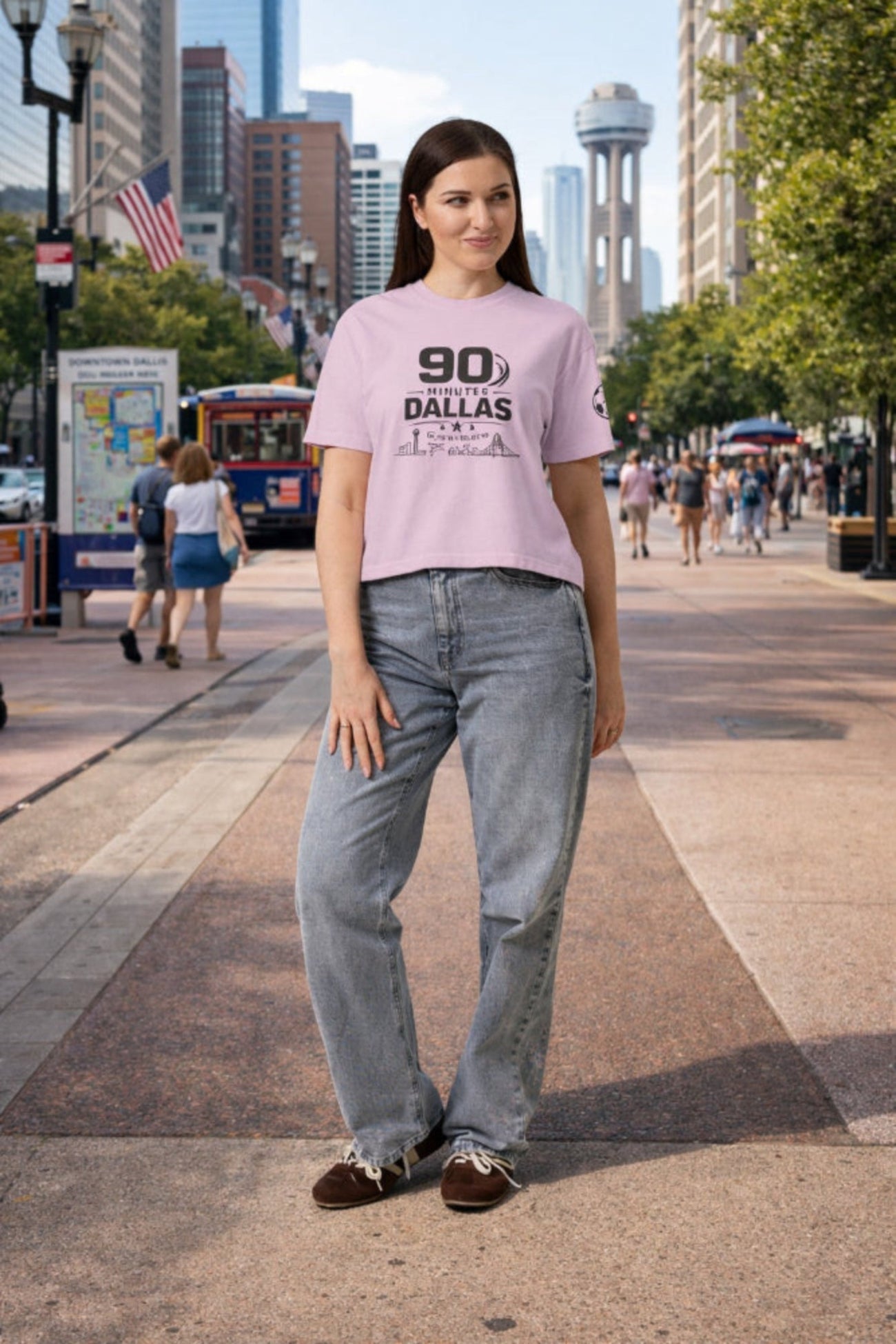 Woman wearing a '90s Dallas' t-shirt on a city street with tall buildings in the background